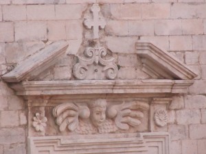 decorazioni di stile tardo rinascimentale sul timpano della finestra quadrangolare della facciata, che sostituì un più antico rosone gotico (foto Stefano Dark)